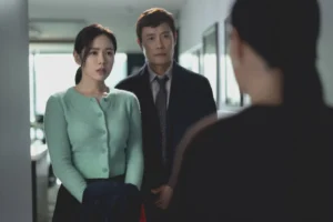 No Other Choice Park Chan-wook AI analysis: Lead actors Lee Byung-hun and Son Ye-jin as Man-su and his wife in a sterile office, portraying the emotional strain of technological unemployment.